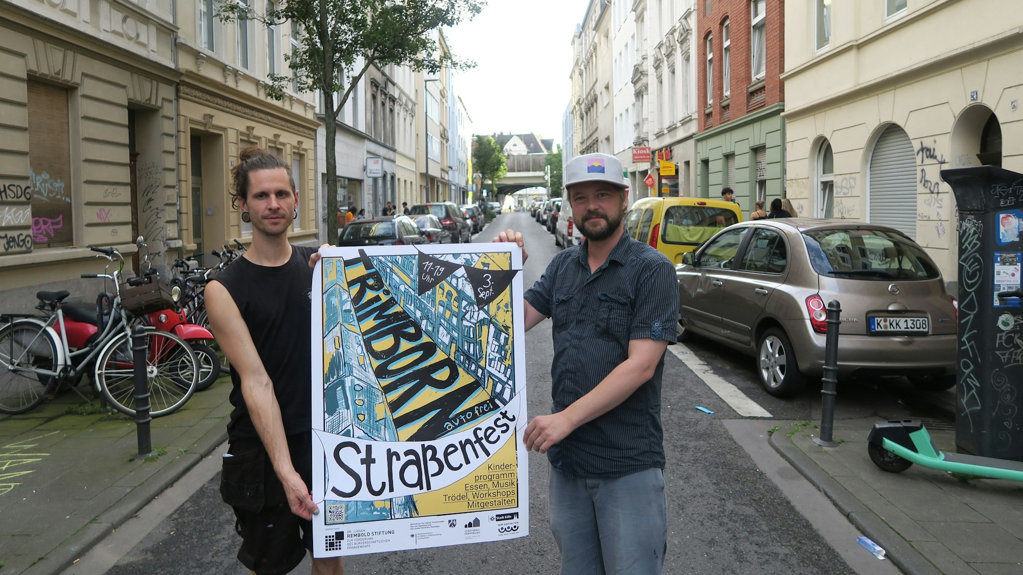 Zwei Männer halten ein Plakat in die Luft.