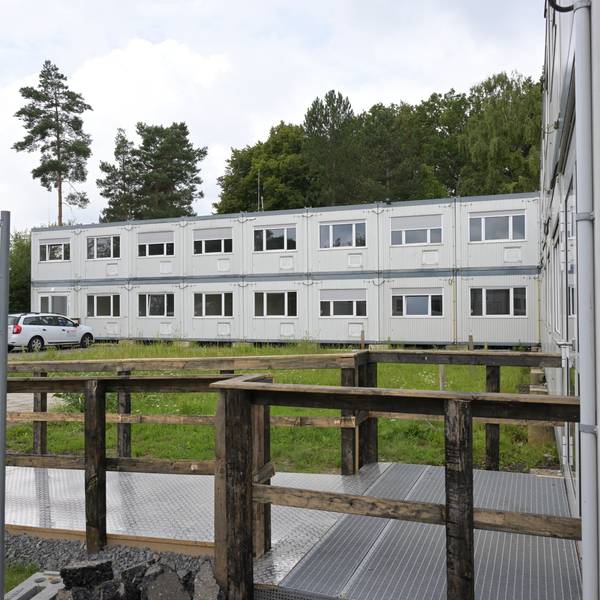 Zu sehen sind zwei Riegel der grauen zweigeschossigen Containerbauten.
