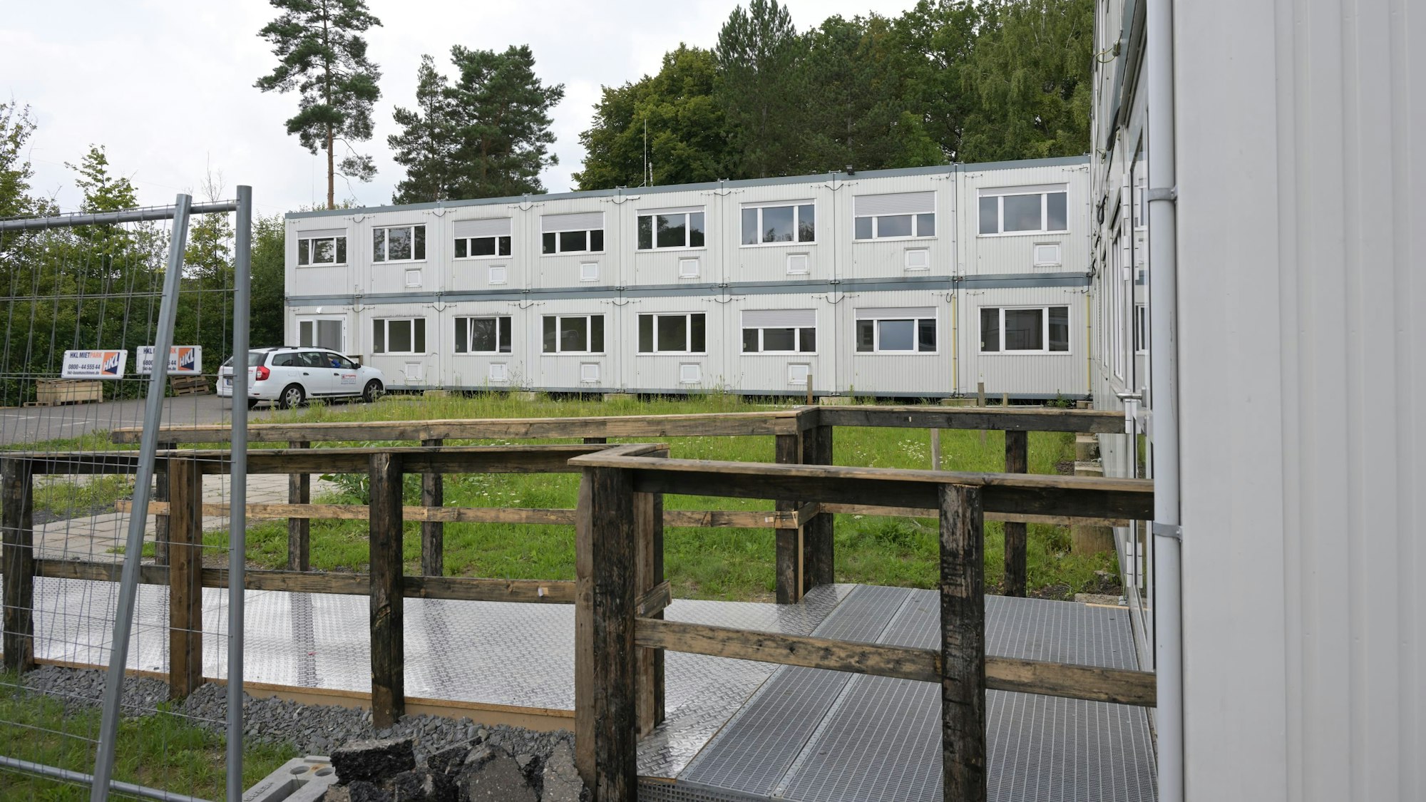 Zu sehen sind zwei Riegel der grauen zweigeschossigen Containerbauten.