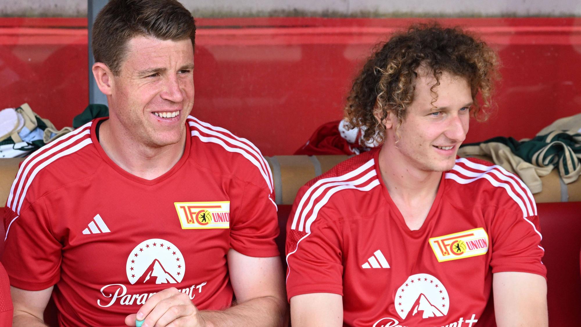Dominique Heintz (l.) und Alex Kral sitzen bei einem Testspiel gegen Kiel auf der Bank von Union Berlin.