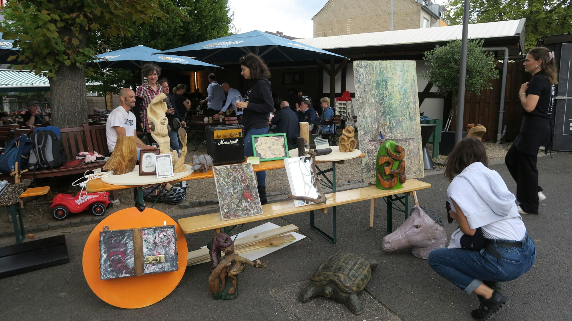 Mehrere Kunstwerke sind an einem Stand ausgestellt.