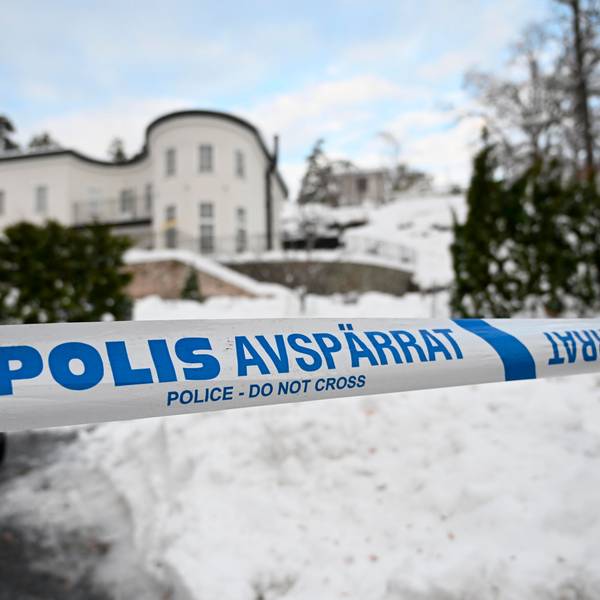Absperrband der Polizei sichert einen Bereich vor einem Haus ab.