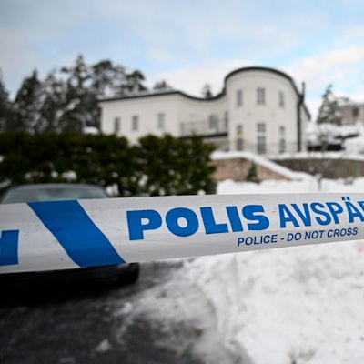 Absperrband der Polizei sichert einen Bereich vor einem Haus ab.
