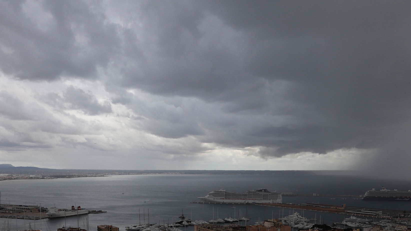 Dunkle Regenwolken hängen über der Bucht und einem Hafen auf Mallorca (Symbolbild).