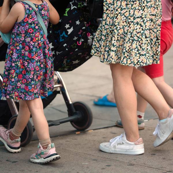 Eine Frau schiebt einen Kinderwagen und geht begleitet von mehreren Kindern. Die Ampel-Koalition hat sich beim Streitthema Kindergrundsicherung geeinigt.