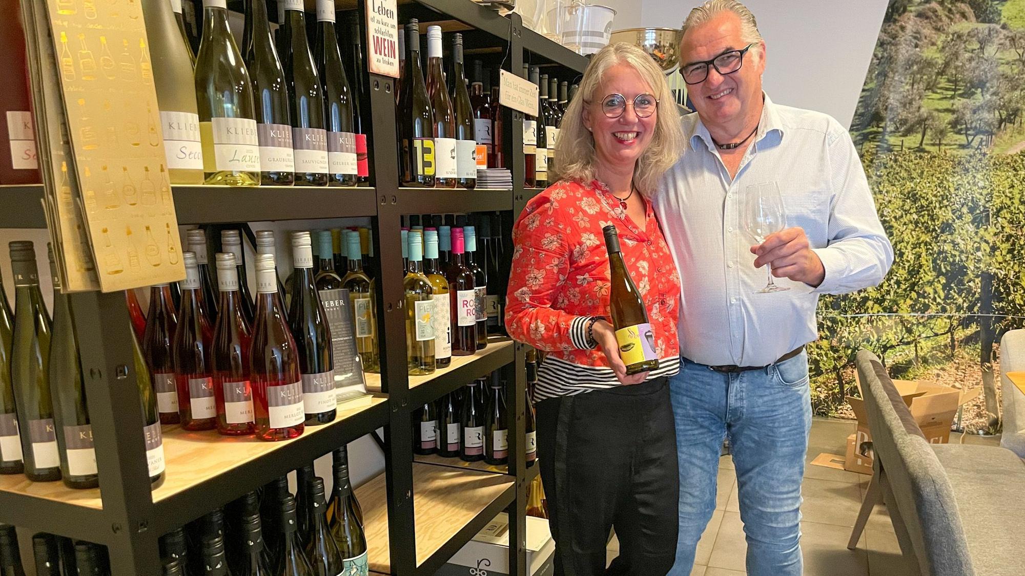 Sandra und Uli Brücker stehen an einem Weinregal.