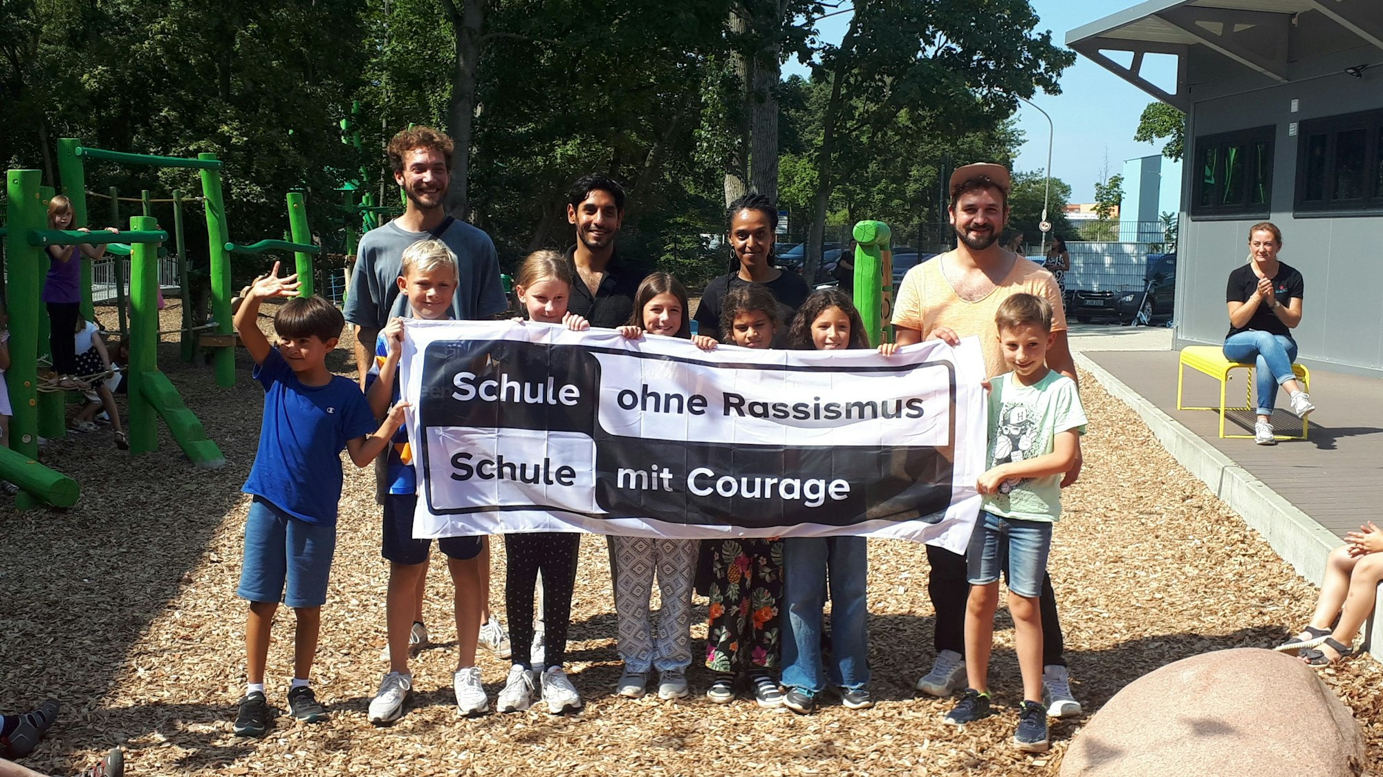 Schülerinnen und Schüler der GGS halten ein Transparent hoch mit dem Schriftzug „Schule ohne Rassismus, Schule mit Courage“.