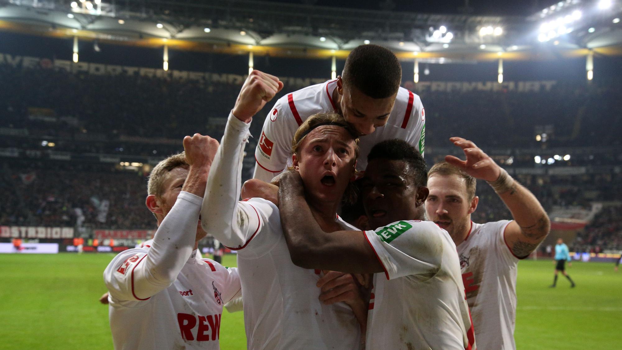 Spieler des 1. FC Köln umringen ihren Kollegen Sebastian Bornauw nach seinem Torerfolg. Einer springt ihm von hinten auf die Schultern.