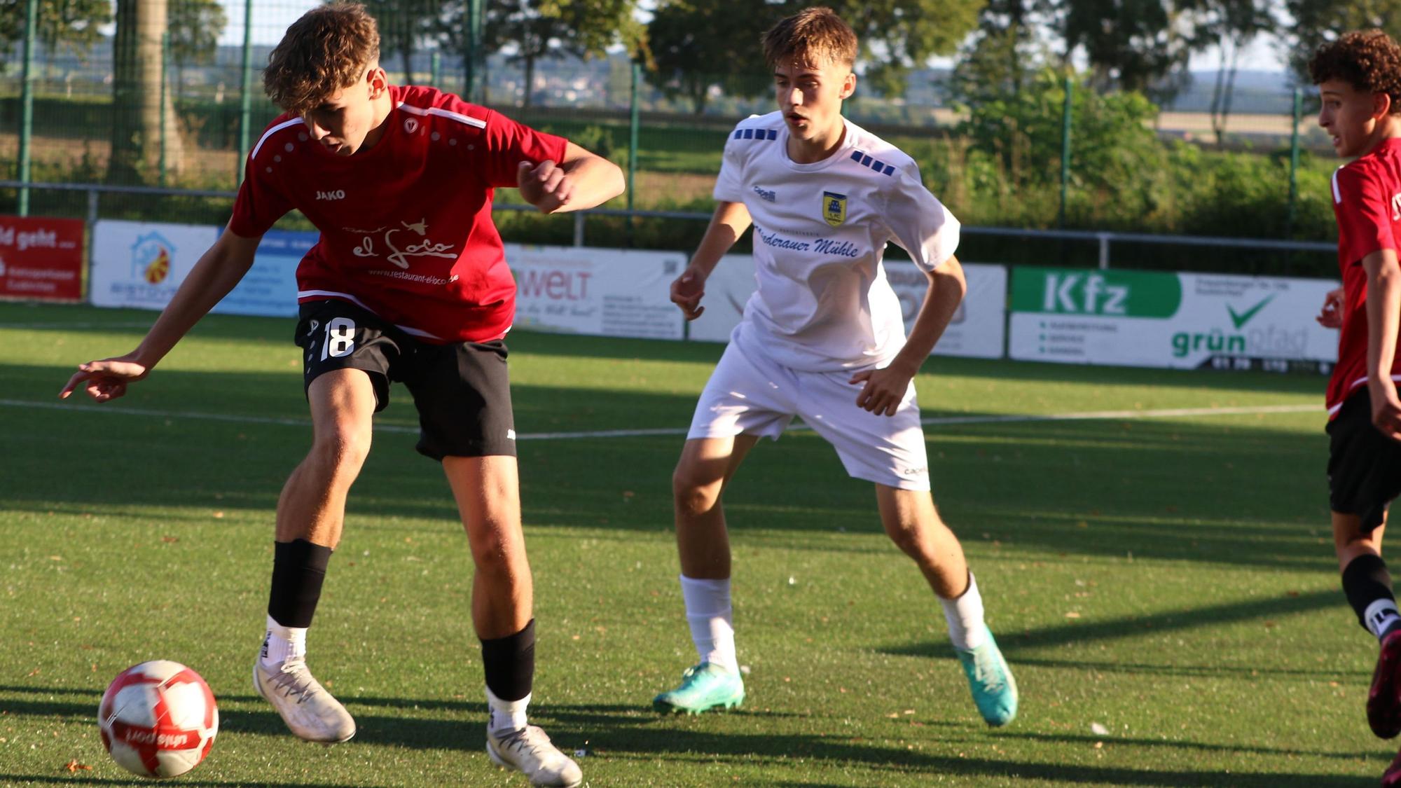 Ein Spieler der JSG Erft 01 schirmt den Ball vor einem Dürener Gegenspieler ab.