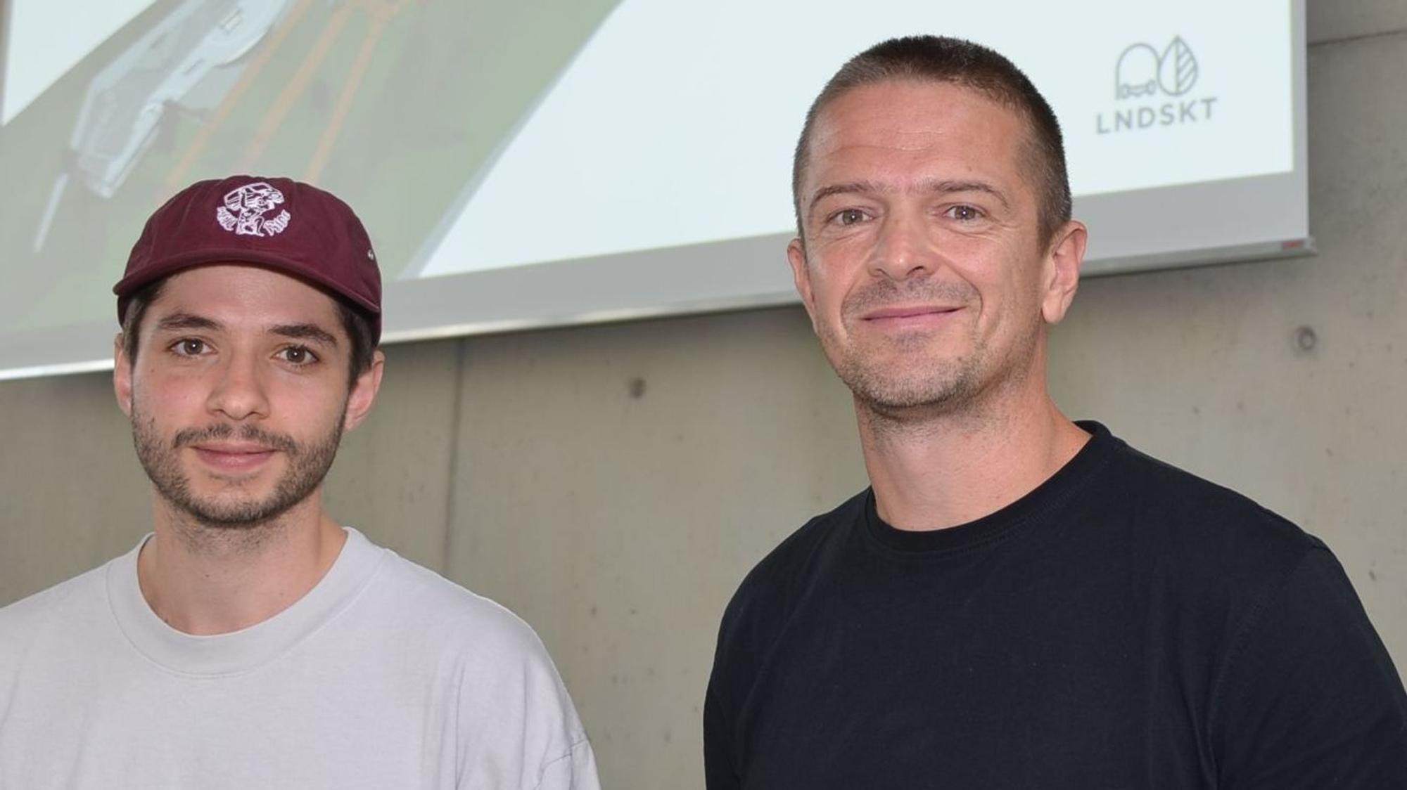 Daniel Schreitmüller (links) und Tobias Hunger von der Landskate GmbH in Köln planen den Rollsport an der Klus in der Ortschaft Niederhof. Jetzt haben sie in Waldbröls Bürgerdorf am Alsberg ihre Pläne in 3D vorgestellt. Sie stehen vor einer Leinwand.