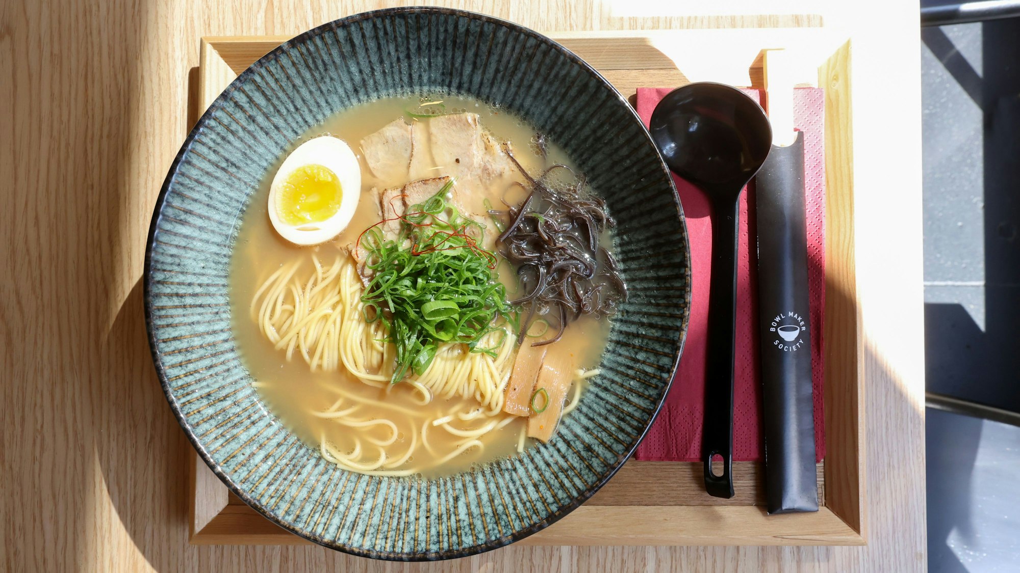 Eine japanische Nudelsuppe in einer Schüssel auf einem Tablett.