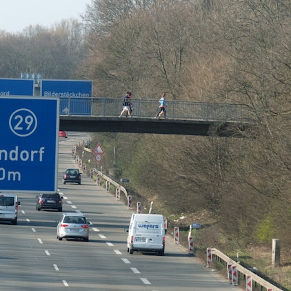 Auf der Stadtautobahn A57 fahren Autos. Ein blaues Schild zeigt die Ausfahrt 29 nach Bickendorf in 1000 Metern an.