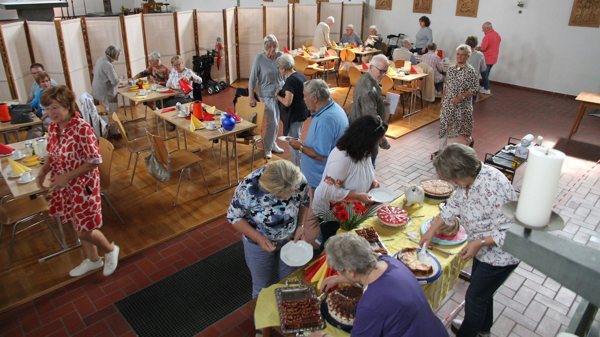 Gäste bedienen sich an einem Kuchenbuffet in einer Kirche.