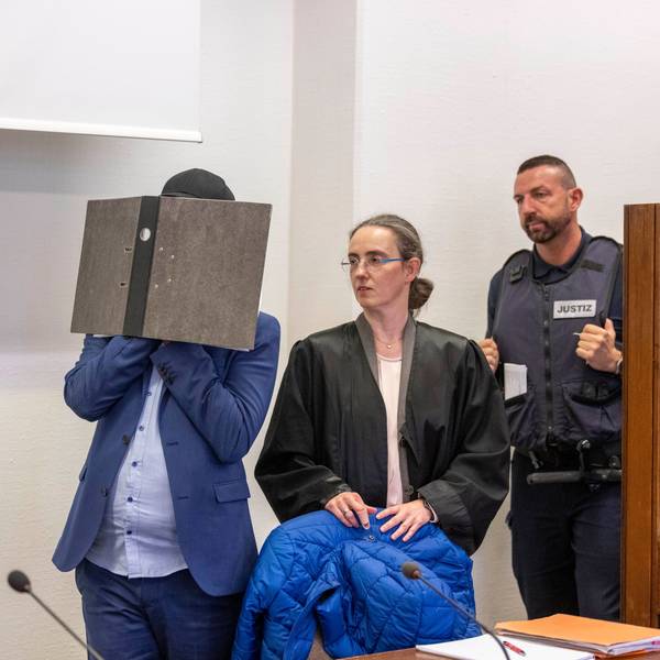 Der Angeklagte kommt vor der Verkündung des Urteils im Prozess wegen sexuellen Missbrauchs an Kindern in den Gerichtssaal des Kölner Landgerichts, während er sein Gesicht hinter einem Aktenordner verbirgt. Seine beiden Rechtsanwälte Jürgen Schüttler (links) und Sybille Weber (rechts) erwarten den Angeklagten im Gerichtssaal.