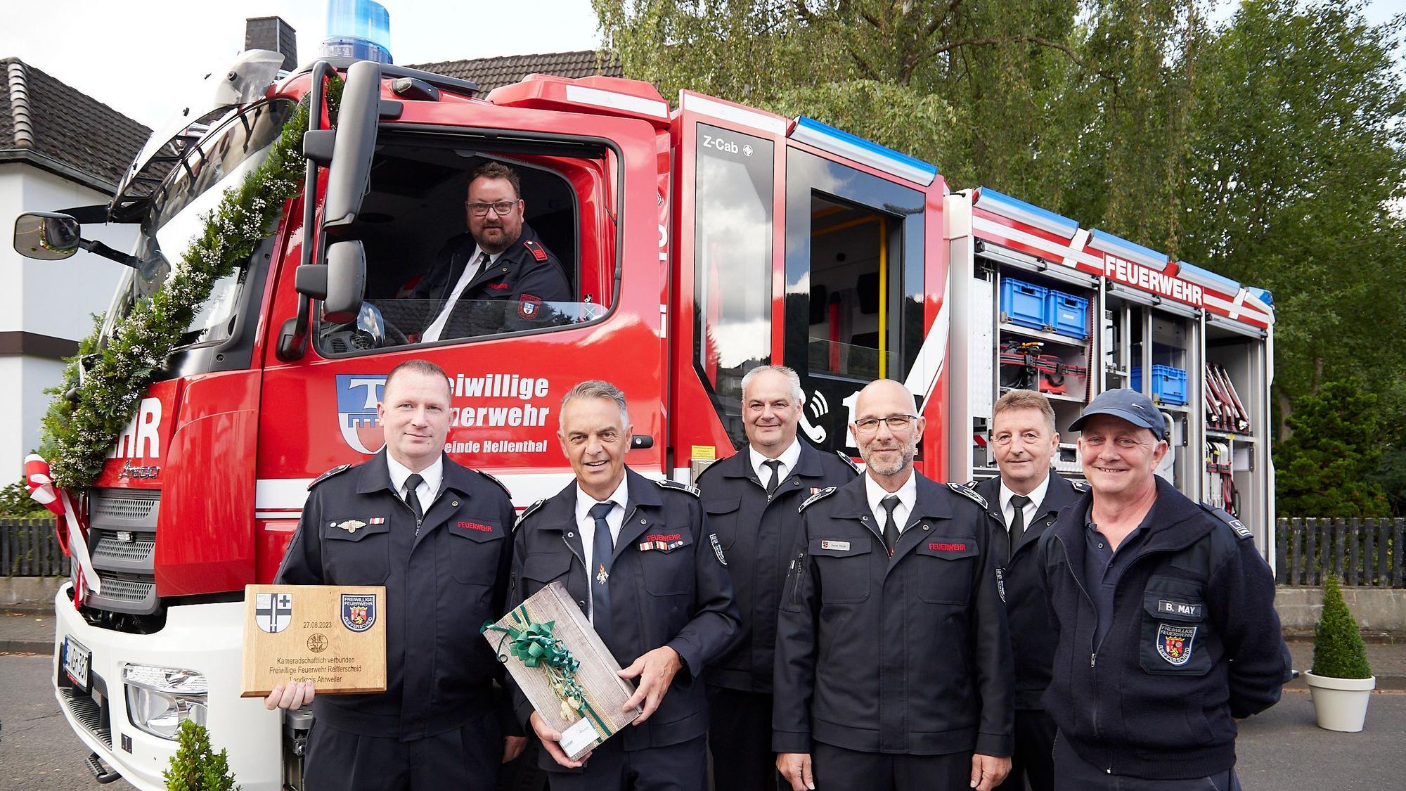 Sechs Männer stehen vor einem neuen und geschmückten Feuerwehrfahrzeug: Offiziell übergeben und eingesegnet ist das LF 10 der Löschgruppe Reifferscheid: Roland Mießen (v.l.), Rudolf Westerburg, Marcus Jenniches, Daniel Pützer, Arndt Haas und Bernd May. Am Steuer sitzt Maschinist Andreas Krahe.