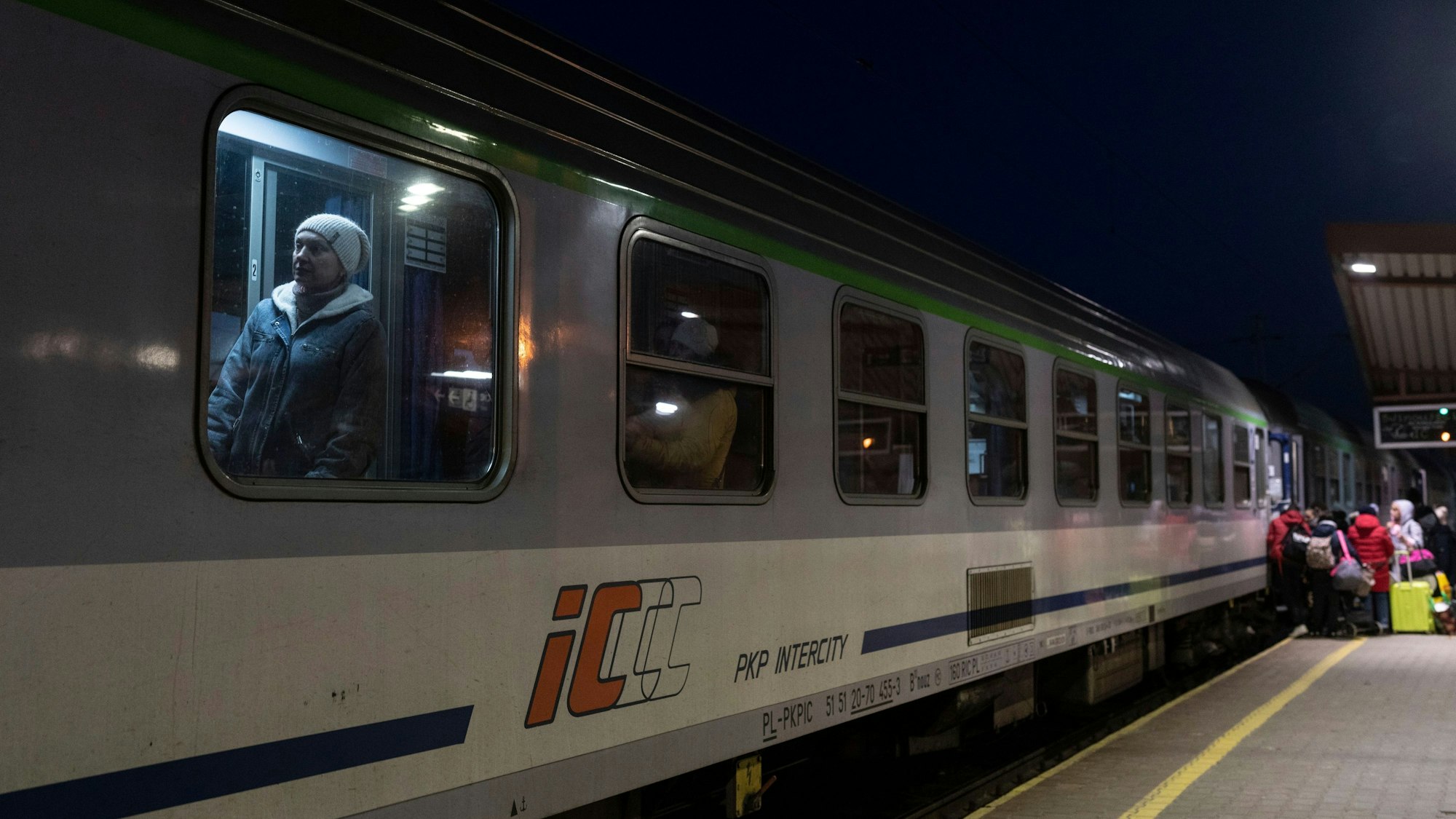 FILE - Ukrainian refugees embark a train bound to Warsaw, at the Przemysl train station, southeastern Poland, on March 11, 2022. Polish security authorities are investigating multiple cases of disruption to railway traffic, after unauthorized radio signals stopped several trains over the weekend. On some of the signals, the Russian national anthem could reportedly be heard in the background.