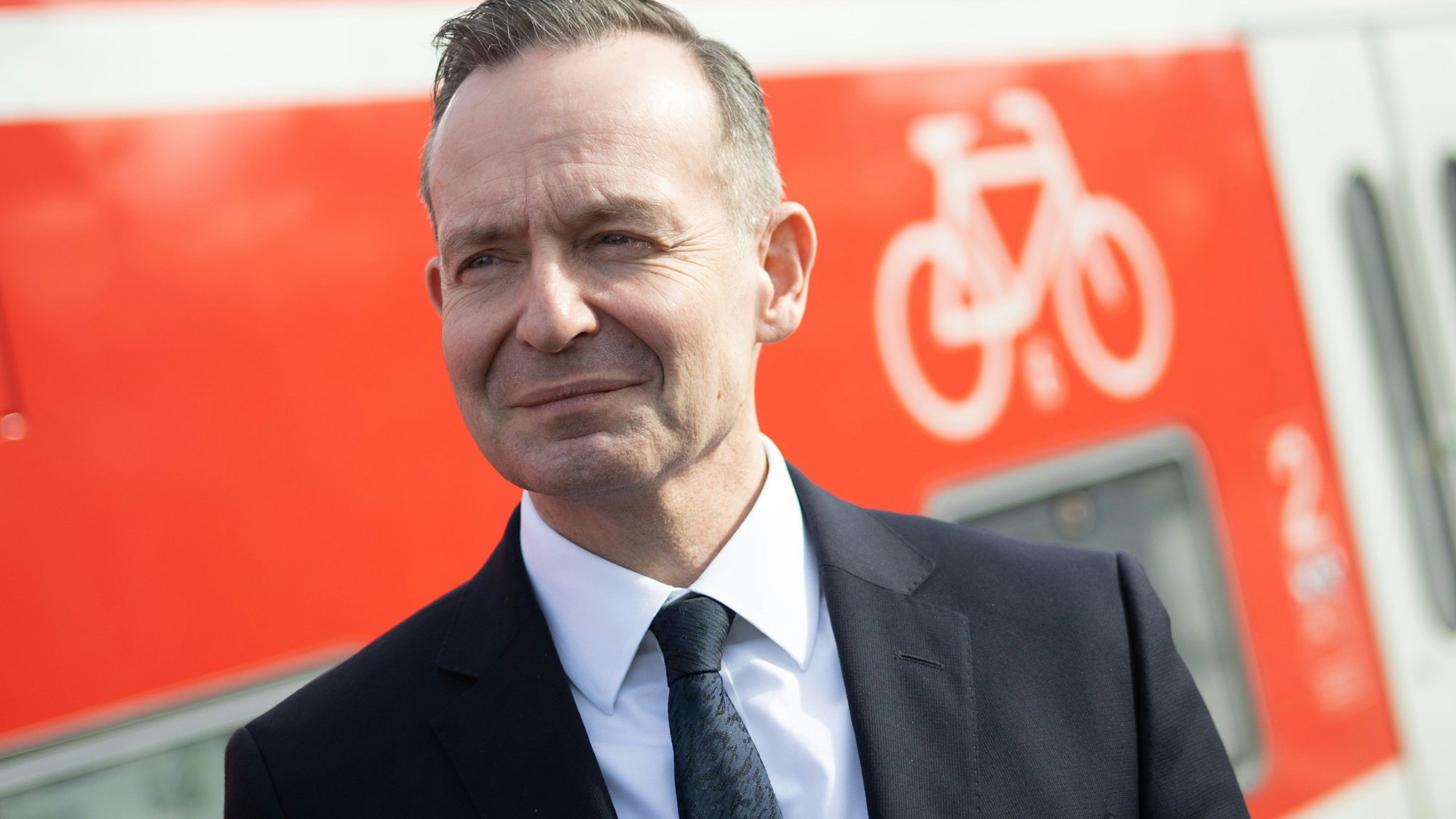 Volker Wissing (FDP), Bundesminister für Verkehr und Digitales, steht neben dem Fahrradabteil eines Regional-Expresses.
