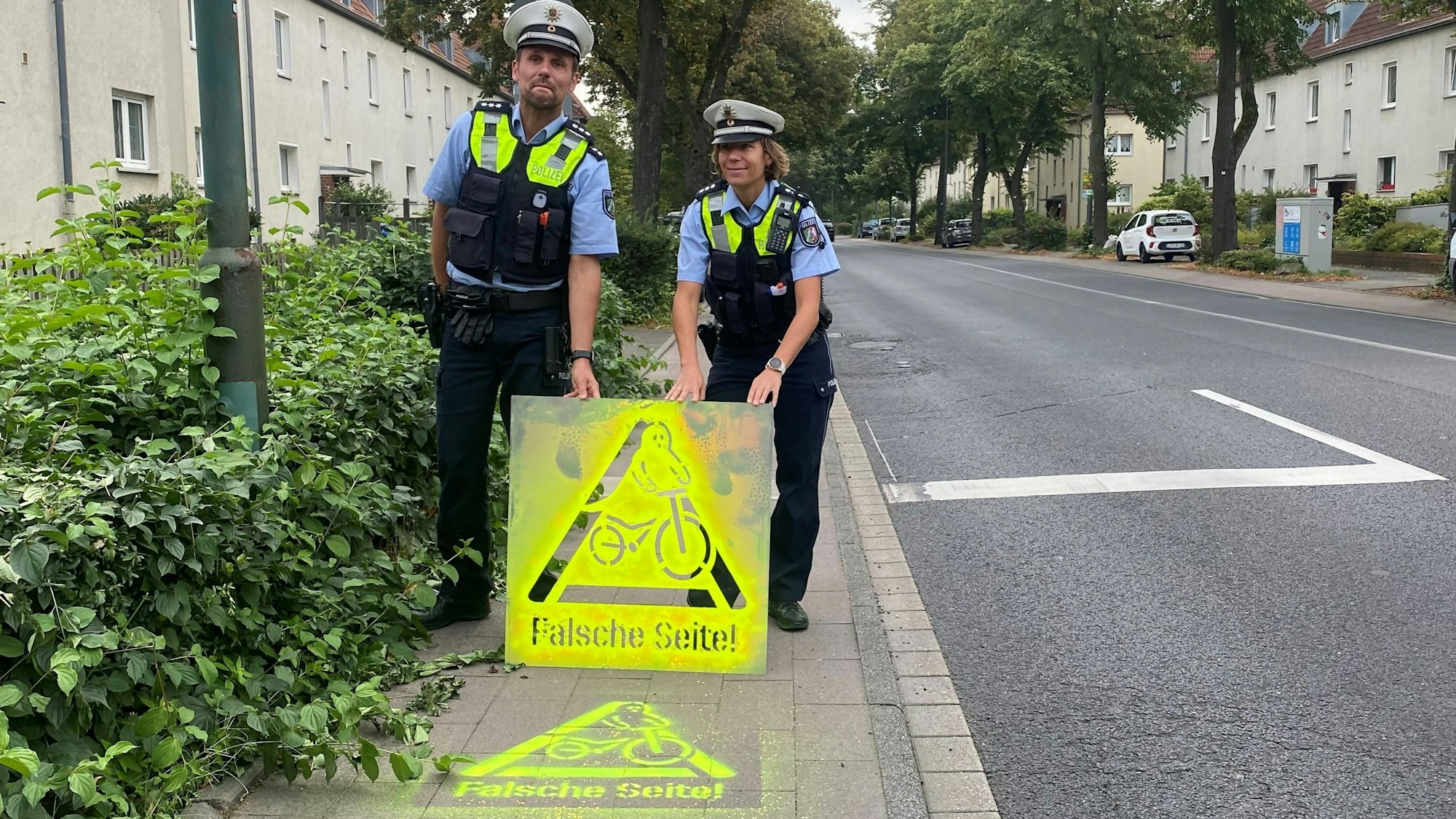 Polizisten haben ein Graffito auf die Straße gesprayt, um Radfahrer zu warnen.