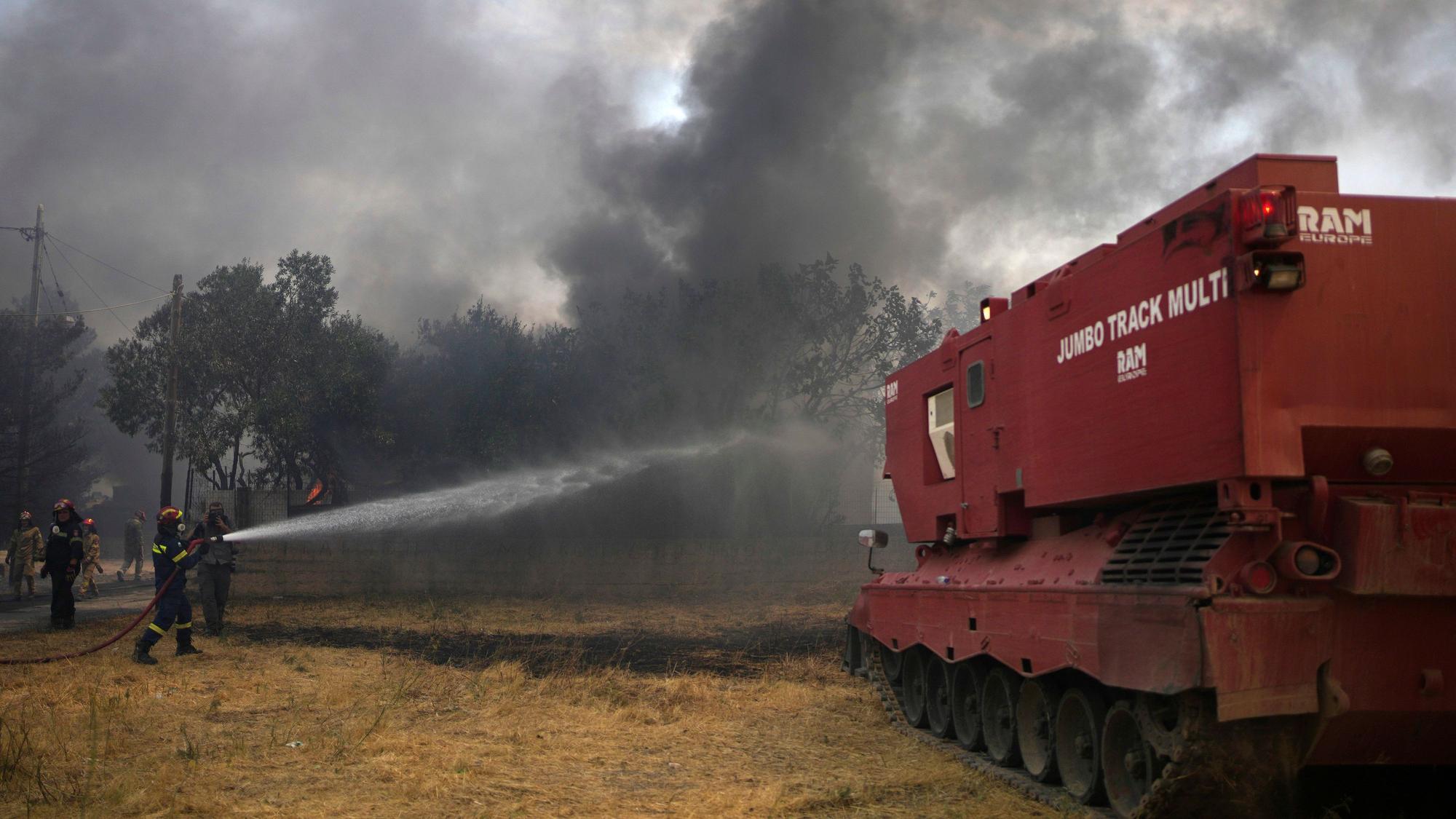 Feuerwehrleute versuchen mit Hilfe eines umgebauten Leopard-Panzers den Waldbrand neben dem christlich-orthodoxen Kloster Agia Paraskevi unter Kontrolle zu bringen. Das Spezialfahrzeug verfügt über eine Kapazität für 15.000 Liter Löschwasser, einer Schaufel für unwegsames Gelände und einer Rettungskammer für zehn Menschen.
