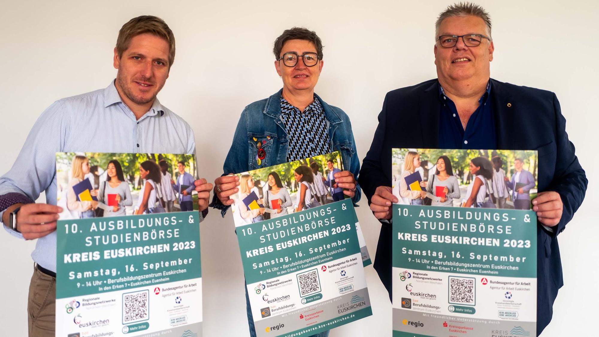 Das Bild zeigt Markus Ramers, Bettina Ismar vom Regioneln Bildungsbüro und Jochen Kupp, Verbandsvorsteher des BZE, wie sie die Plakate hochlaten.