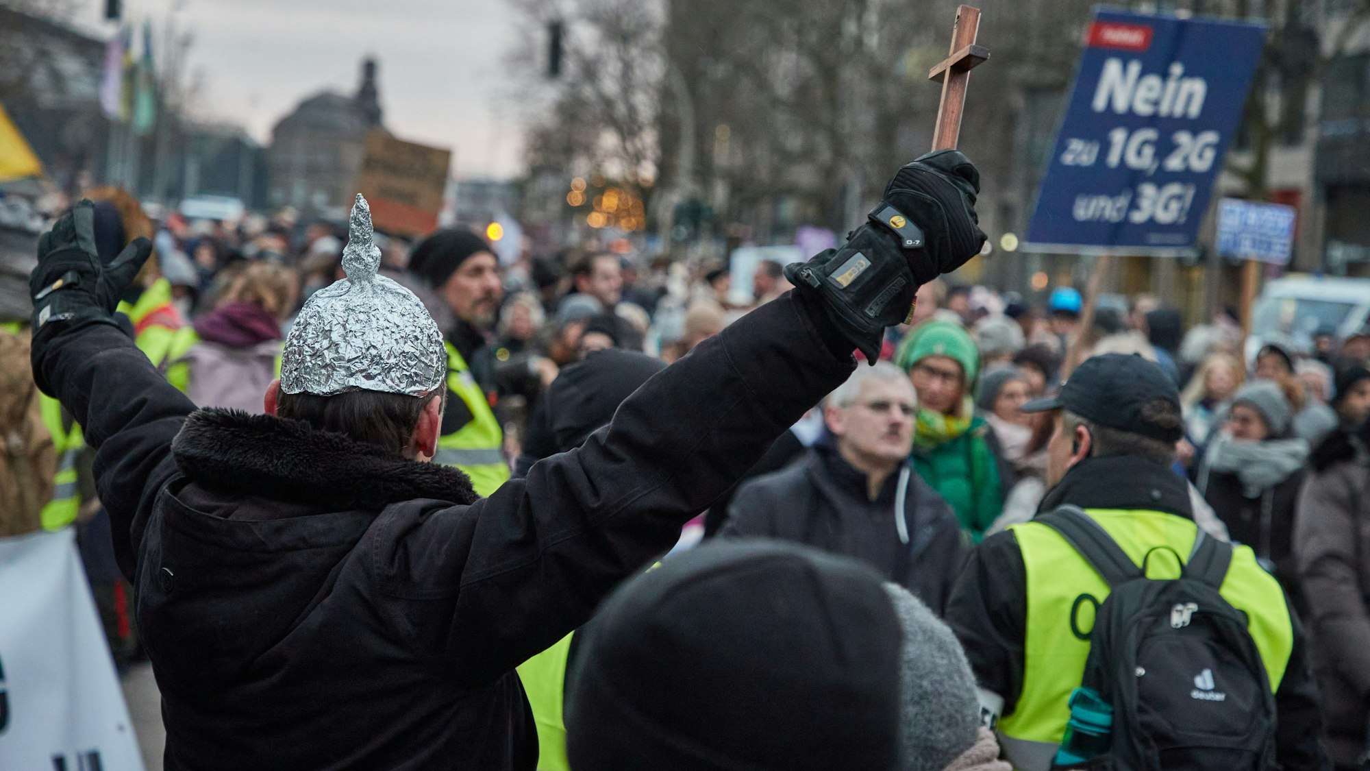 Ein Teilnehmer einer Demonstration gegen Corona-Maßnahmen trägt einen «Aluhut» auf dem Kopf und hält ein Holzkreuz in der Hand. Der Demonstrationszug unter dem Motto «Das Maß ist voll. Hände weg von unseren Kindern» verlief durch die Innenstadt.