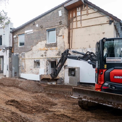 Das Bild zeigt einen Bagger, der den Außenbereich des Hauses in Großbüllesheim umgestaltet.