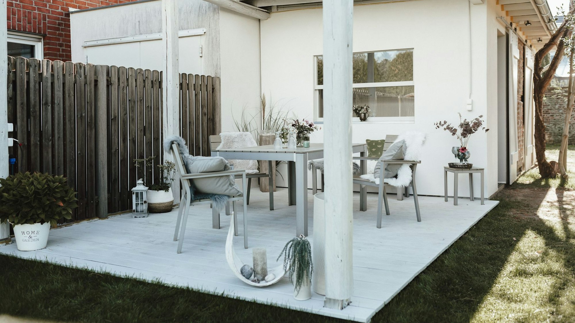 Auf einer Terrasse stehen Tische und Stühle.