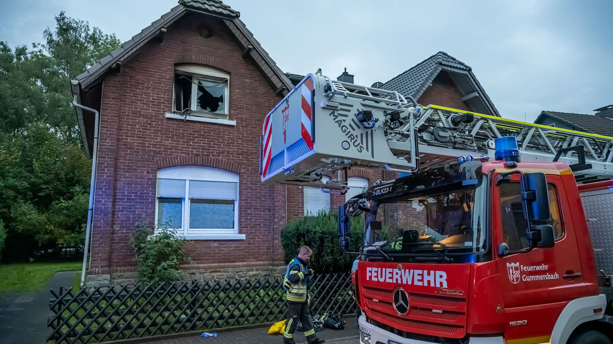 Vor einem Haus steht ein Feuerwehrwagen