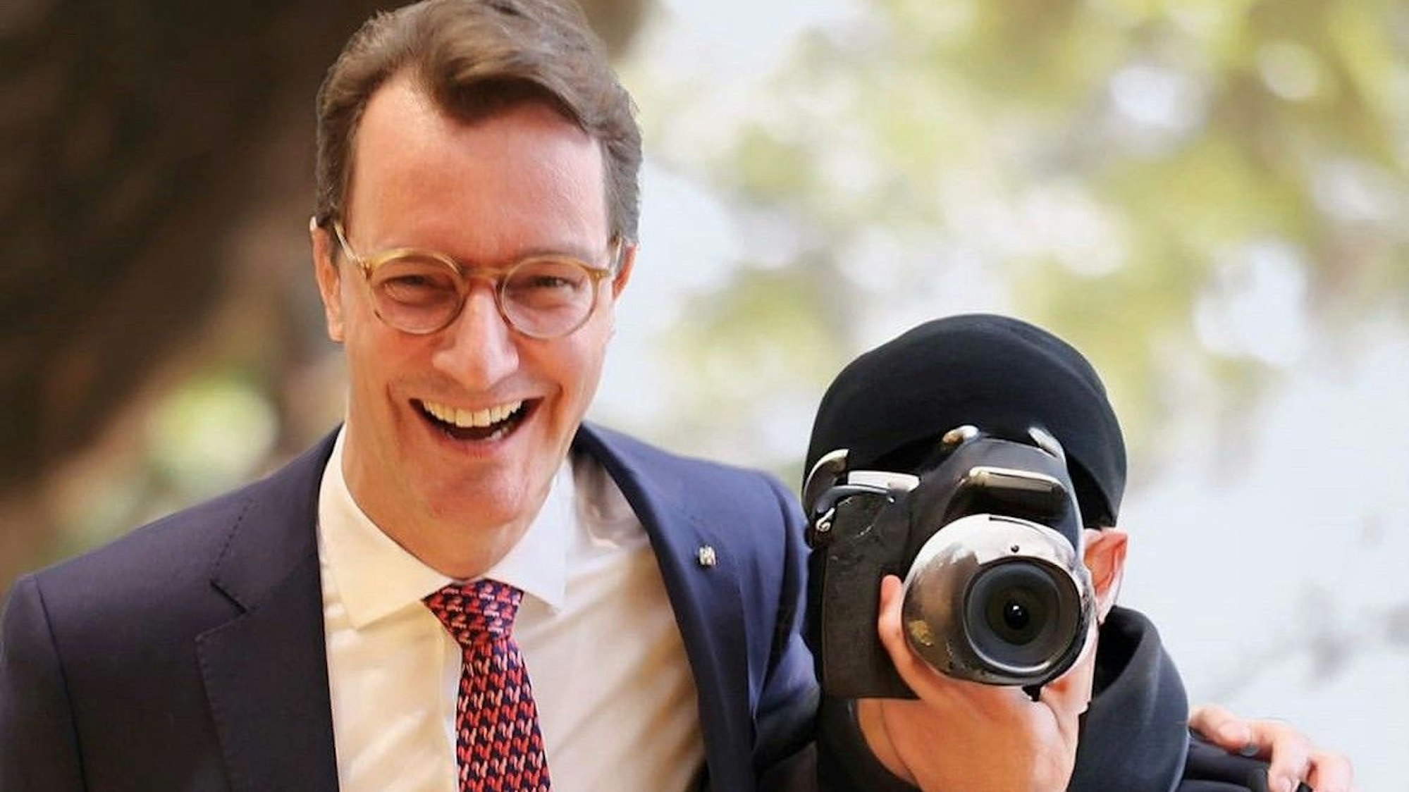 Henrik Wüst herzt einen Fotografen, es handelt sich aber um eine Montage.