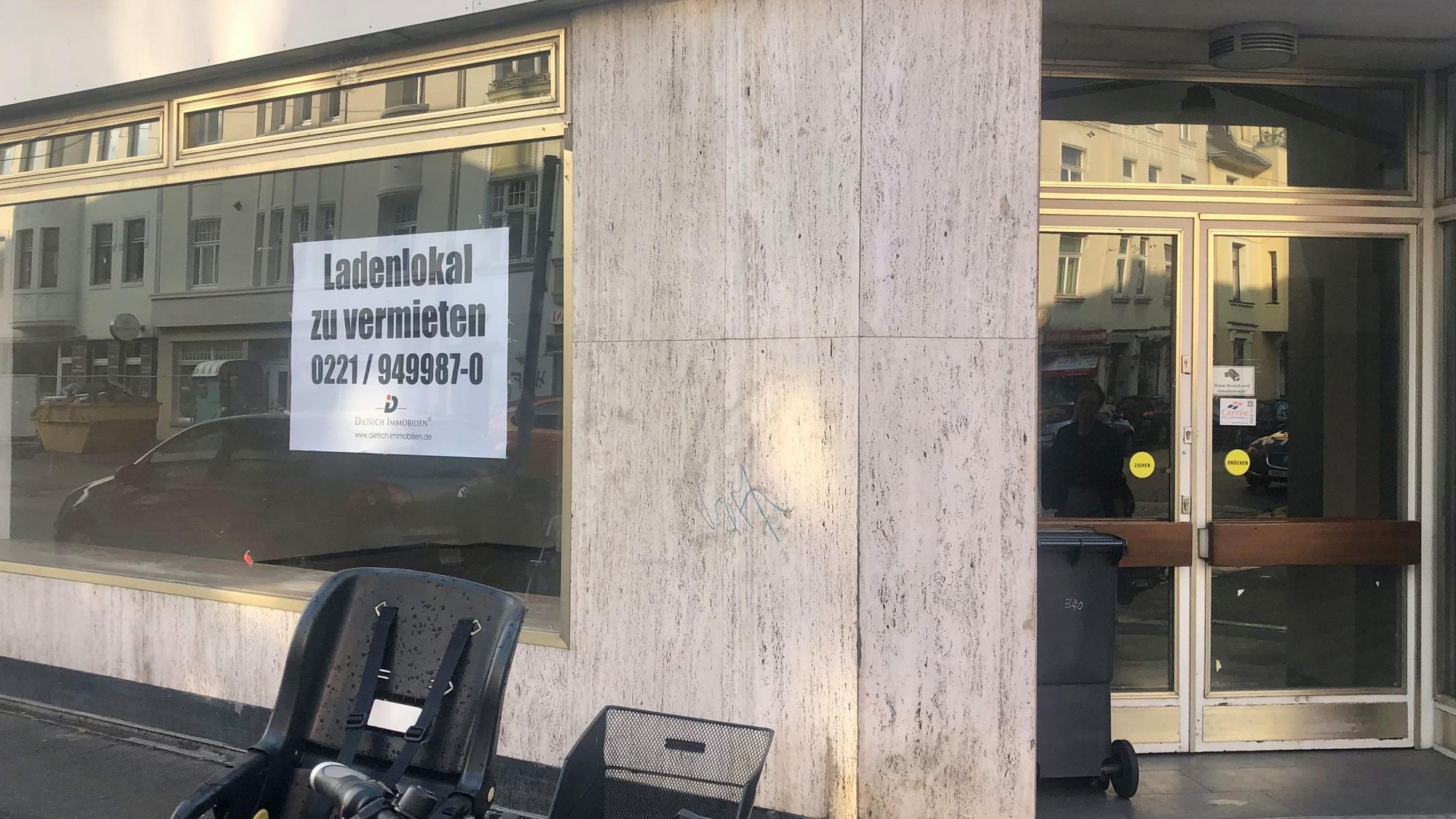 Blick auf ein leeres Ladenlokal, im Schaufenster hängt ein Schild: zu vermieten