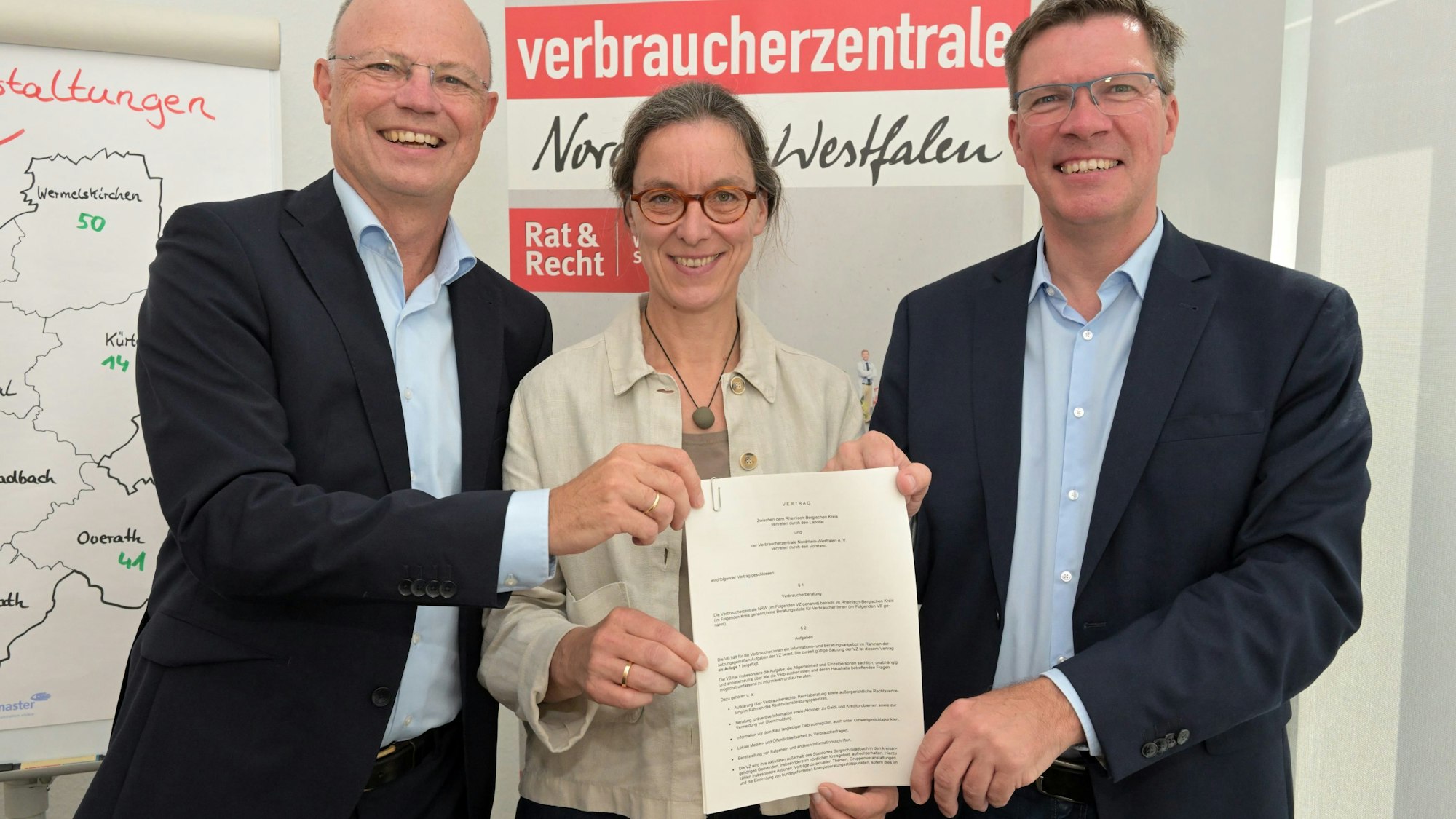 In der Verbraucherzentrale Bergisch Gladbach zeigen (v.l.) Wolfgang Schuldzinski, Brigitte Becker und Landrat Stephan Santelmann den Vertrag.