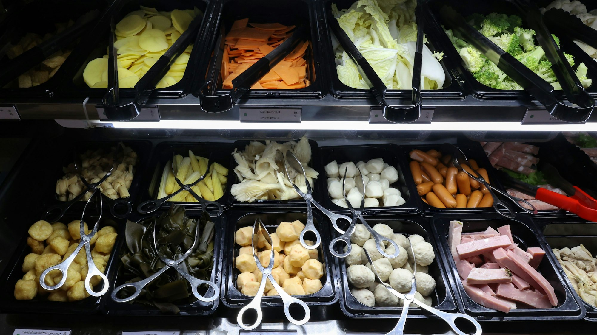 geschnittenes Gemüse und Klöße in schwarzen Behältern