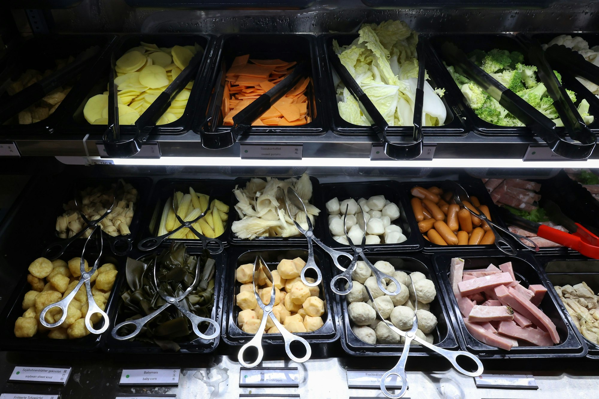 Die Kühltheke mit mehreren Boxen mit verschiedenen Lebensmitteln.