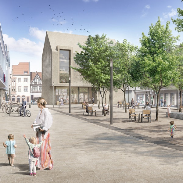 Das Bild zeigt den Janshof mit vielen Sitzmöbeln und Bäumen. Im Hintergrund ist der neue Rathausanbau mit seiner beigen Fassade zu sehen.