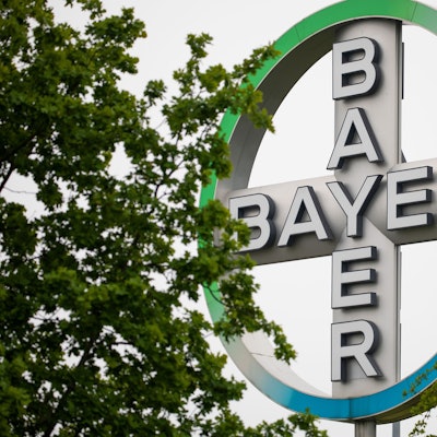 Das Bayer Kreuz, Logo des Unternehmens Bayer, steht zwischen Bäumen am Flughafen Köln/Bonn. Der Agrarchemie- und Pharmakonzern Bayer verkauft seine Tierarzneimittel-Sparte für 7,6 Milliarden US-Dollar (6,85 Mrd Euro) an den US-Konzern Elanco. Das teilte Bayer am Dienstag in Leverkusen mit. +++ dpa-Bildfunk +++