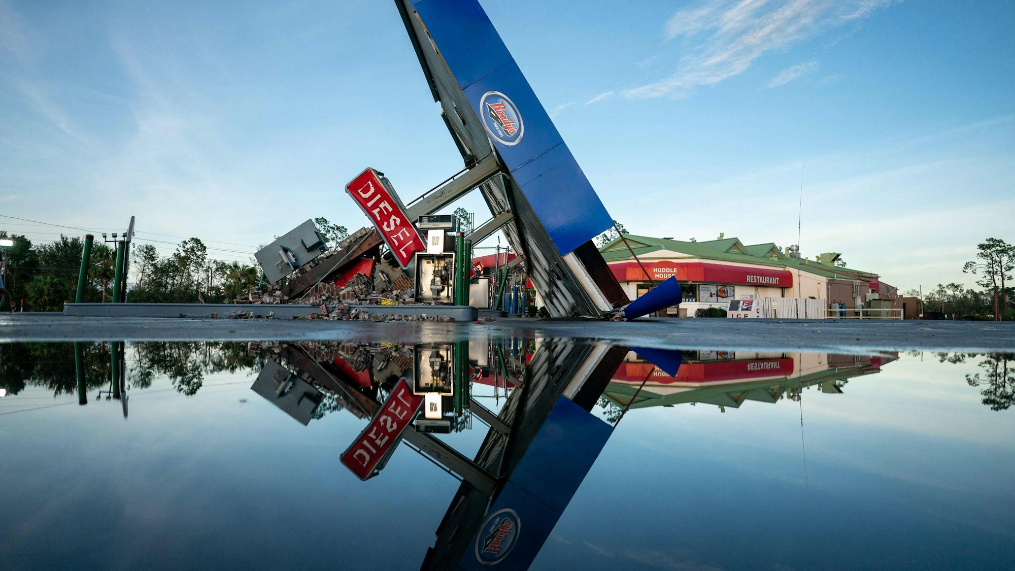 Eine zerstörte Tankstelle spiegelt sich im vom Hurrikan „Idalia“ an Land gedrückten Wasser im US-Bundesstaat Florida. Der Sturm hat für Verwüstung an der US-Küste gesorgt.
