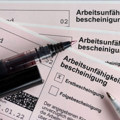Ausschnitte von Arbeitsunfähigkeitsbescheinigungen und Stiften