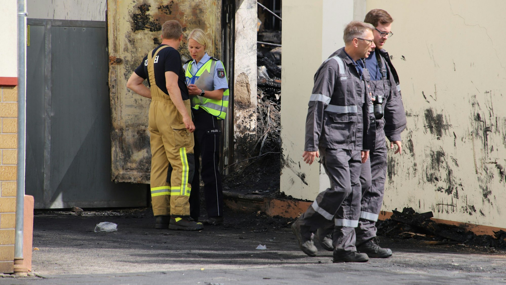 Brandermittler und Sachverständige untersuchen eine Brandruine.