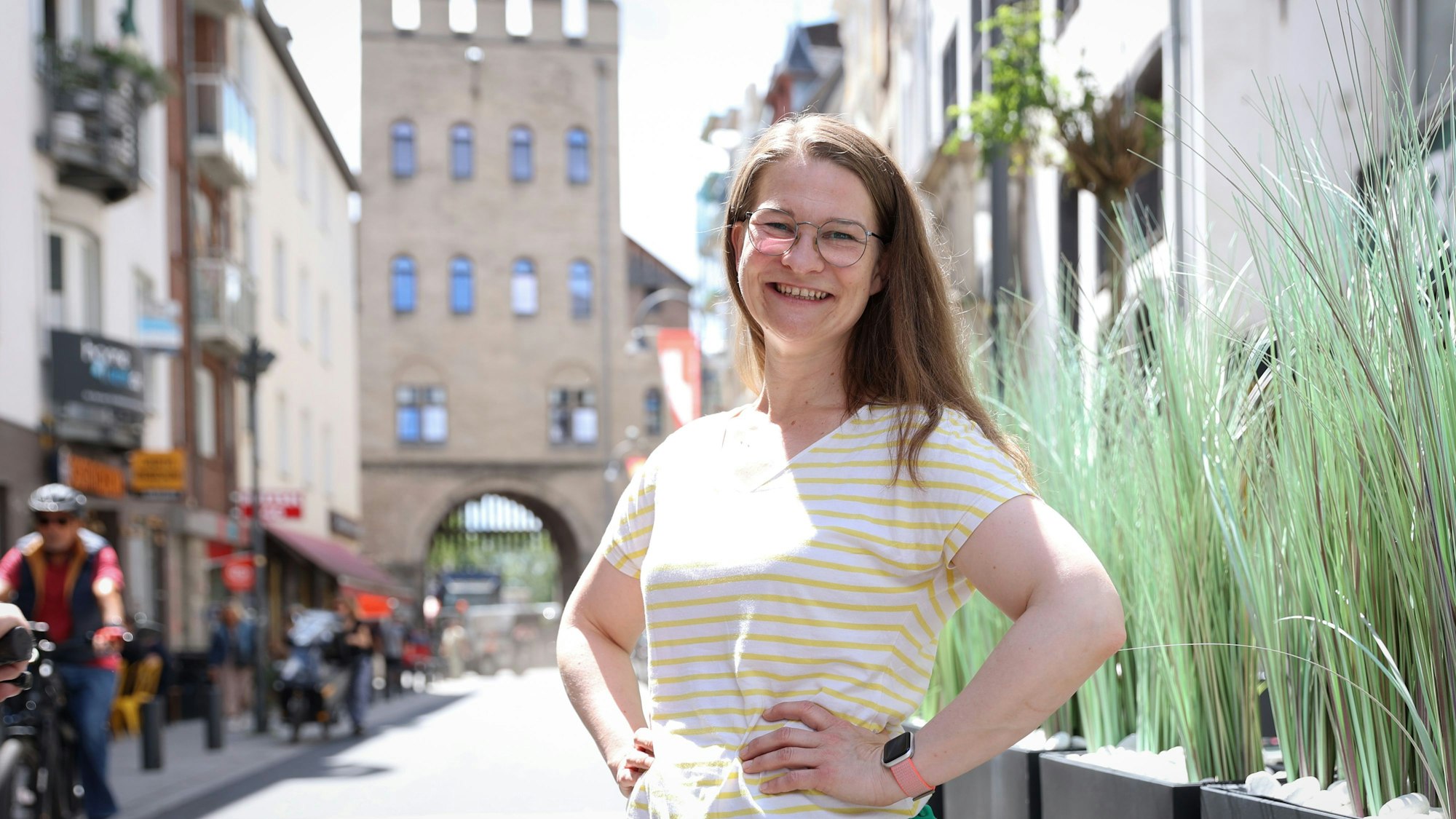 Vera Passy posiert lächelnd vor der Severinstorburg.