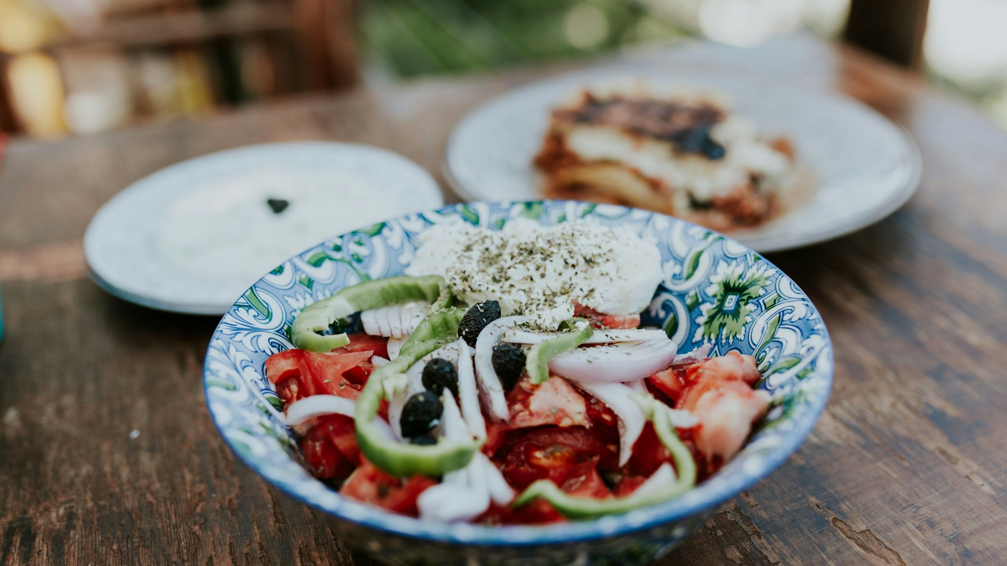 Traditionell griechisches Gericht aus Moussaka mit Tsatsiki und griechischem Salat.