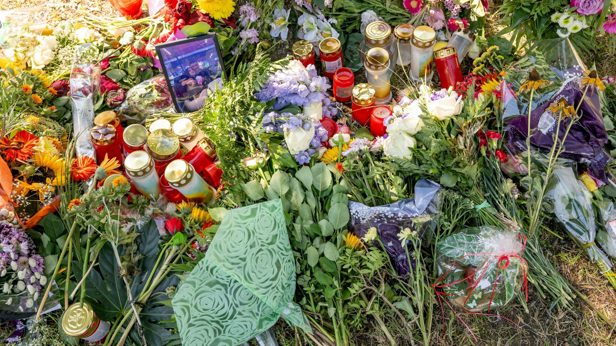 Bayern, Ingolstadt: Blumen, Kerzen und Bilder liegen an einem Baum