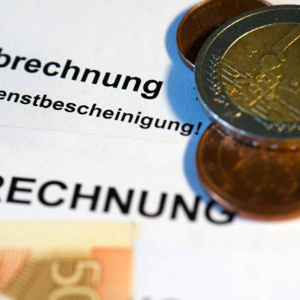Auf einer Verdienstbescheinigung liegen Euromünzen und Geldscheine.