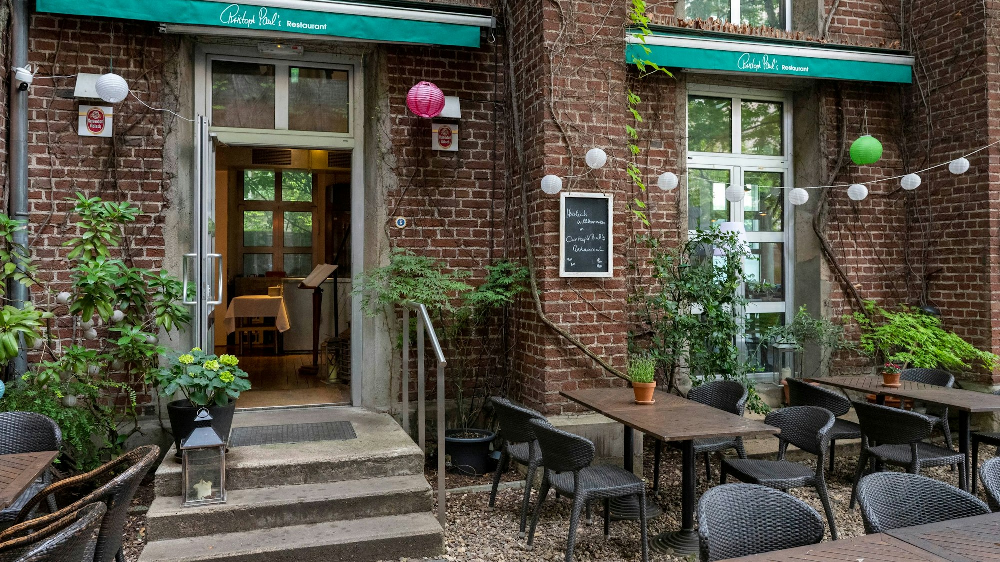 Außenansicht des Hauses mit Backstein und Pflanzen.