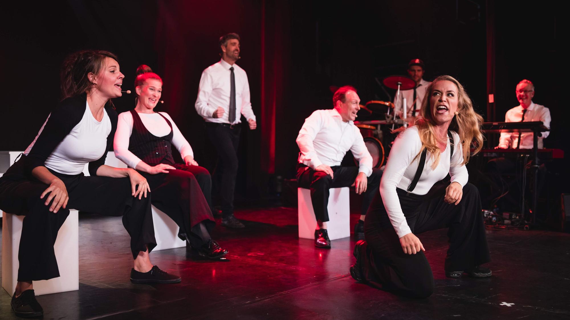 Männer und Frauen spielen eine Theaterszene