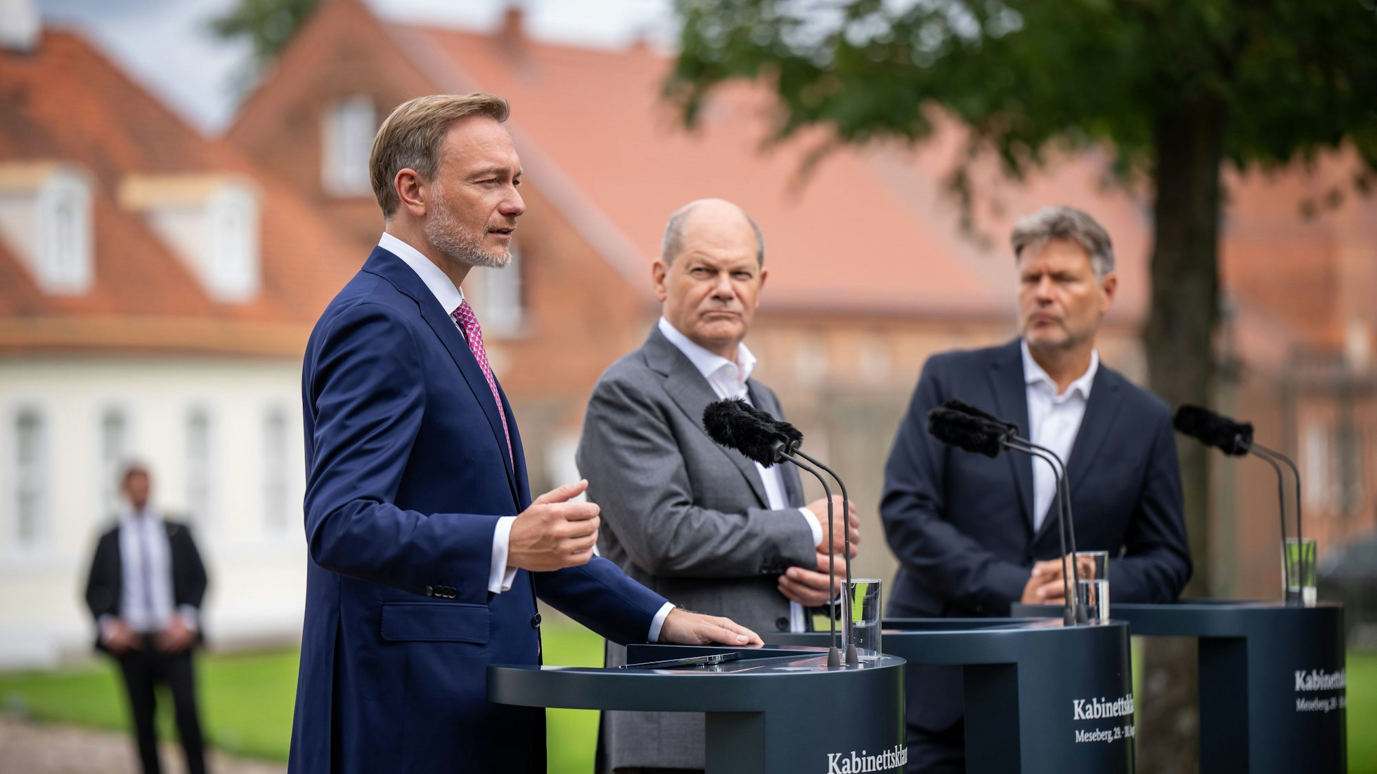 30.08.2023, Brandenburg, Meseberg: Bundeskanzler Olaf Scholz (SPD, M), Christian Lindner (FDP, l), Bundesminister der Finanzen,und Robert Habeck (Bündnis 90/Die Grünen), Bundesminister für Wirtschaft und Klimaschutz, nehmen am Pressesstatement nach der Halbzeit-Klausur des Bundeskabinetts vor Schloss Meseberg teil. Bundeskanzler Olaf Scholz (SPD) und seine 16 Minister sind in Brandenburg zur fünften Klausurtagung der Ampelregierung zusammengekommen. Foto: Michael Kappeler/dpa +++ dpa-Bildfunk +++
