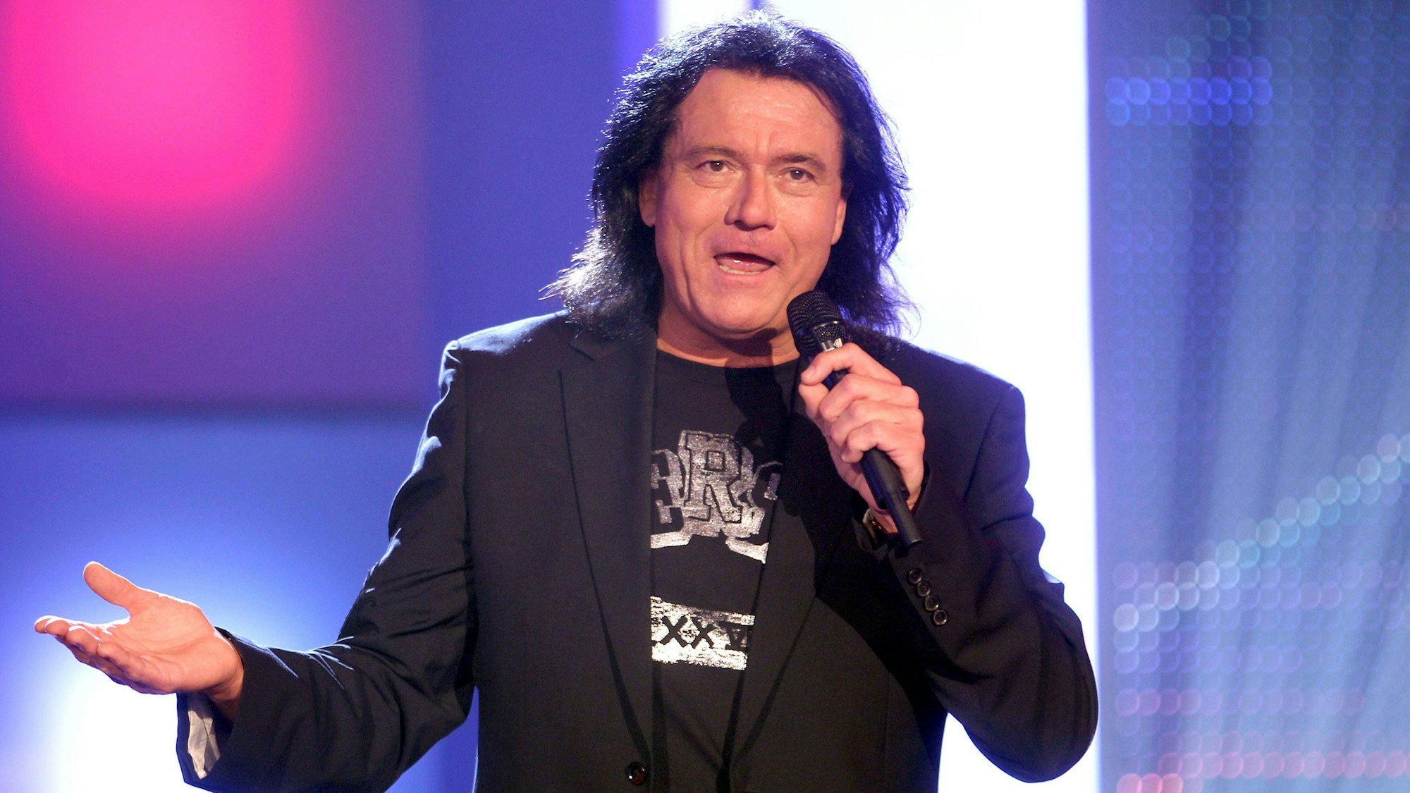 Andreas Martin singt in ein Mikrofon.