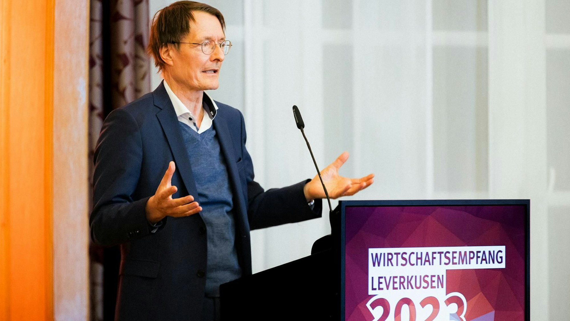 Karl Lauterbach spricht an einem Mikrofon.