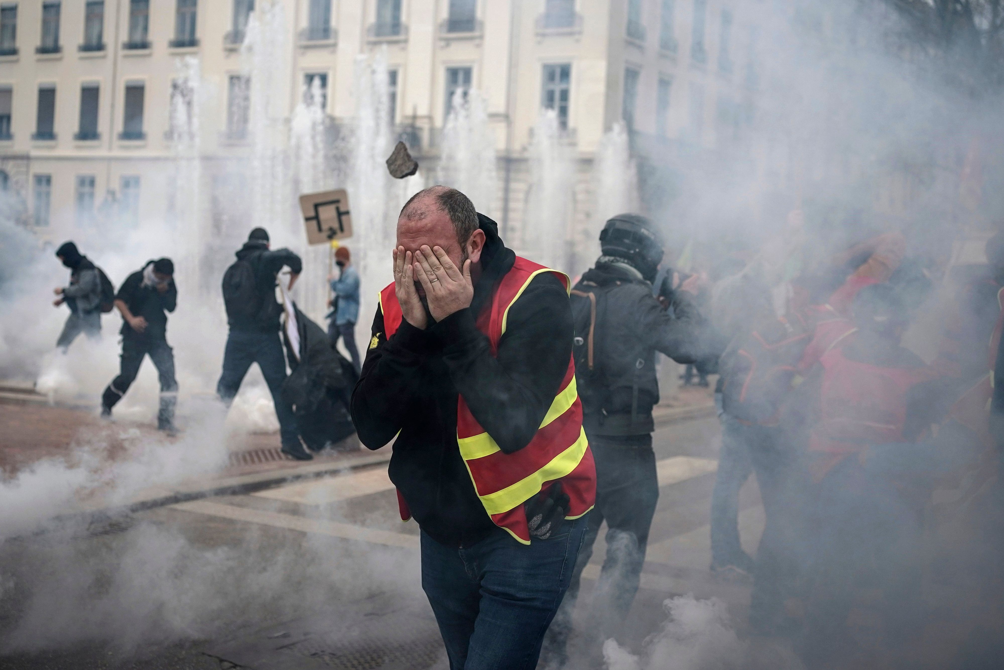 Demonstranten rennen während einer Demonstration durch Tränengas. In Frankreich haben sich die Streiks und Proteste gegen die Rentenreform zugespitzt.