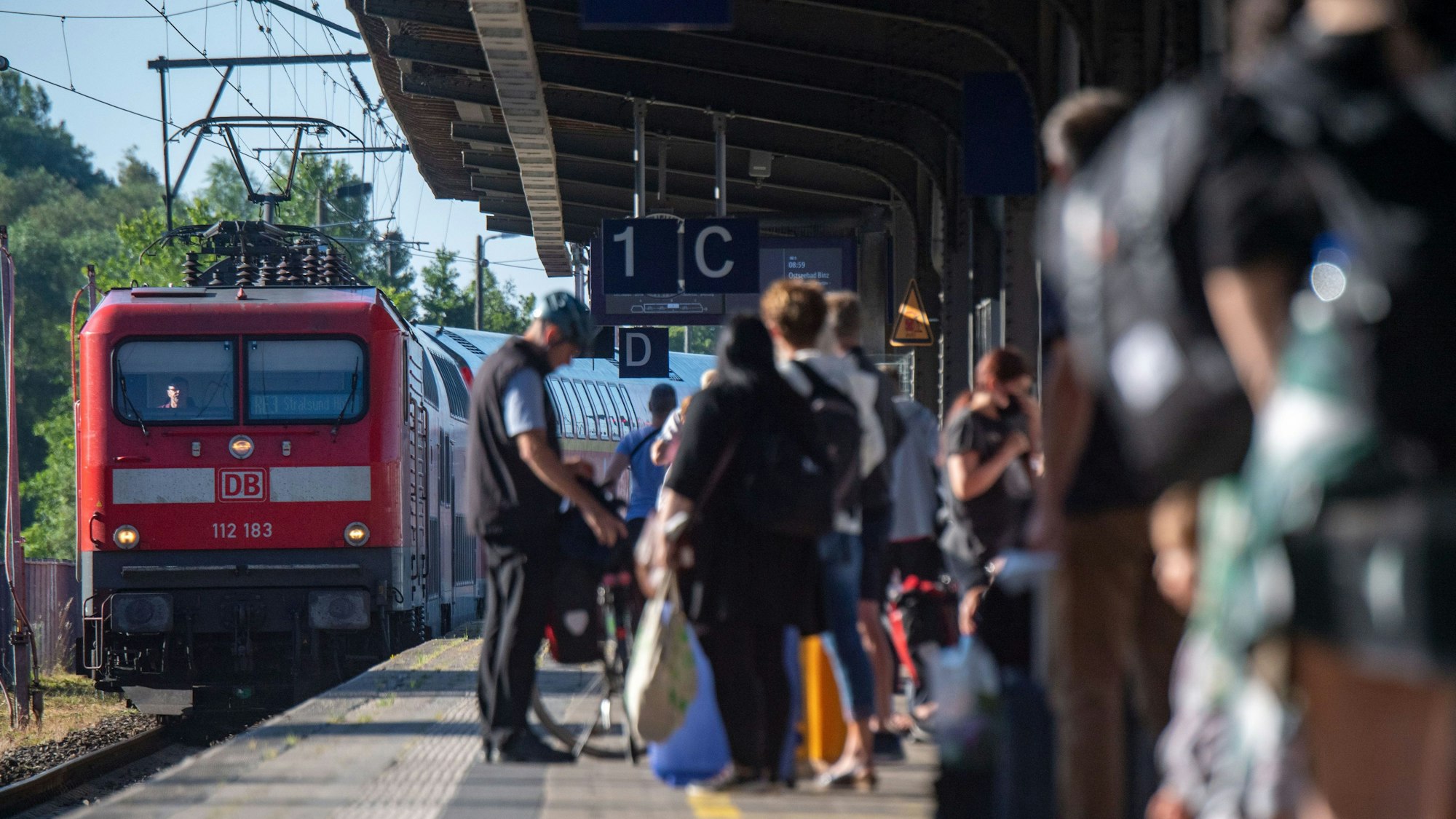 Fahrgäste warten im Bahnhof auf eine Regionalbahn. Das Deutschlandticket hat einer aktuellen Umfrage zufolge Tausende Menschen in den öffentlichen Personennahverkehr gelockt, die diesen zuvor nicht genutzt haben.