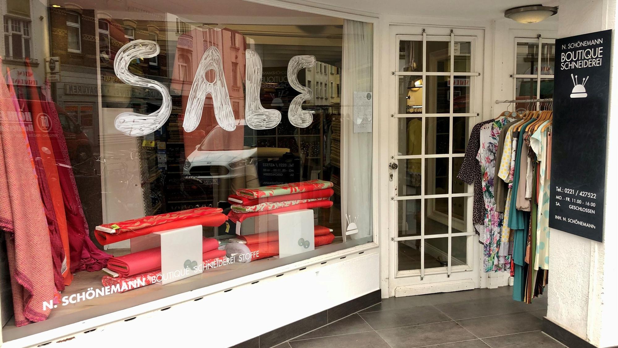 Eine Ladenfront ist zu sehen, auf dem Fenster prangt der Schriftzug Sale.